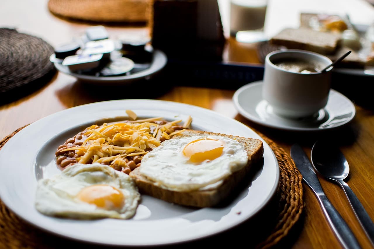 Fried eggs on toast with beans, and a coffee
